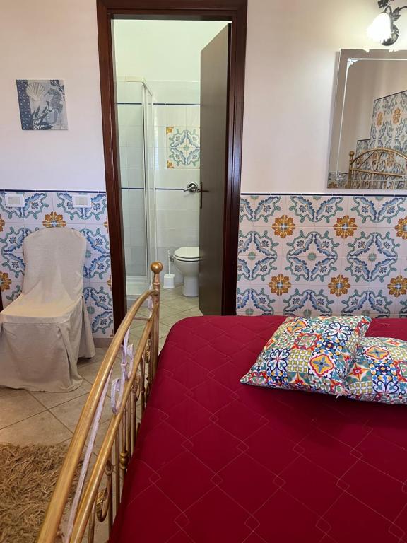 1 dormitorio con cama, aseo y espejo en Baglio Cracchiolo da Tuzzo - Casa Bouganville en San Vito lo Capo