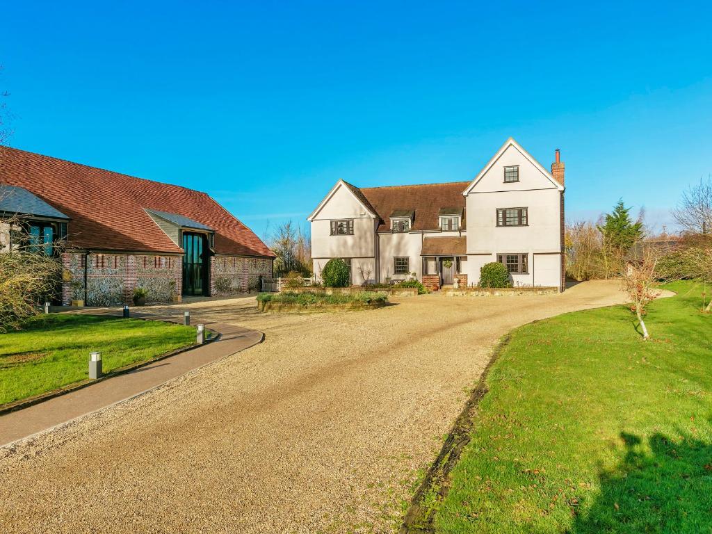 a large white house with a dirt road at Tuffon Hall Farmhouse in Halstead