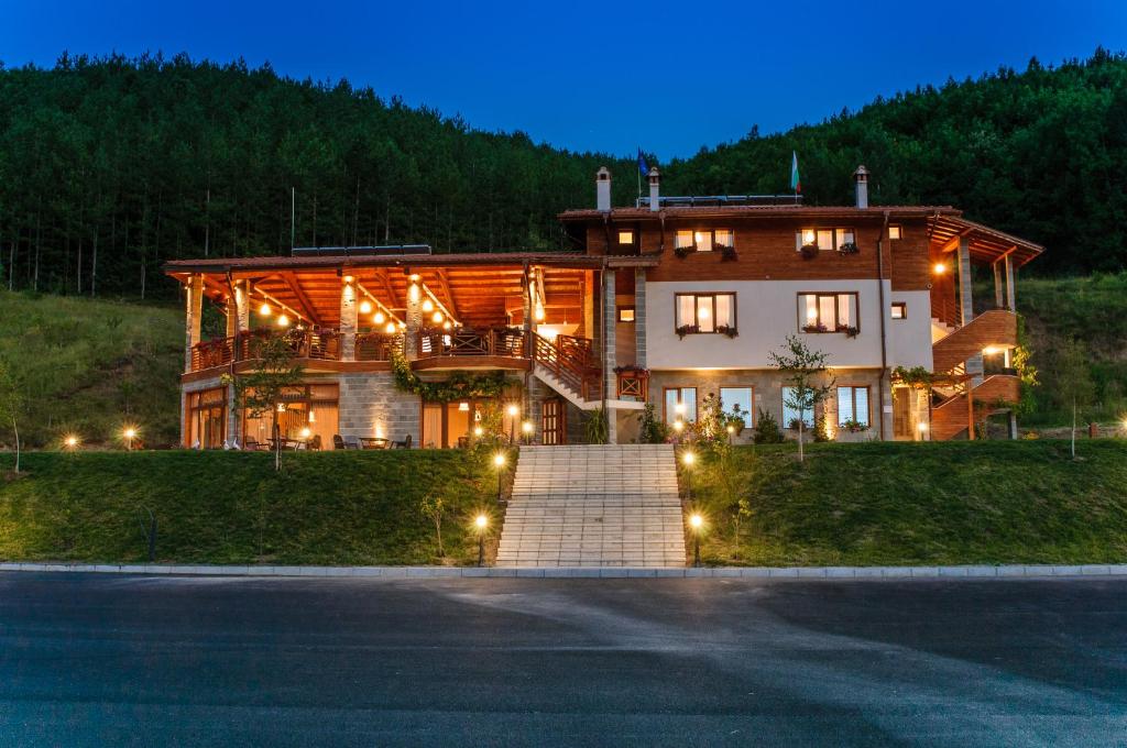ein großes Haus mit Lichtern davor in der Unterkunft Alpine Garden Hotel (Trayanovi Dvori) in Simitli