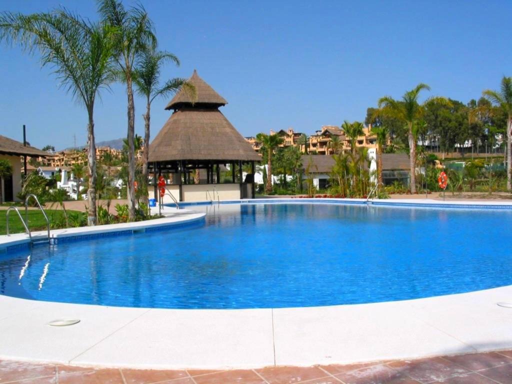 una gran piscina azul con cenador en El Campanario del Paraíso, en Estepona