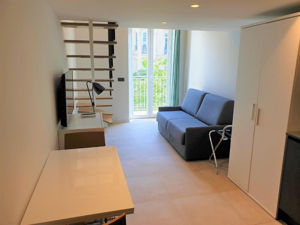 un salon avec un canapé bleu et une télévision dans l'établissement Le duplex proche mer 202, à Nice