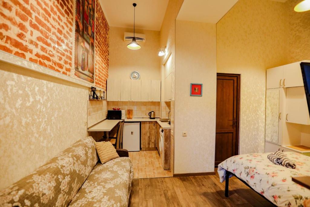 uma sala de estar com um sofá e uma cozinha em Luky apartment on Rustaveli Ave. em Tbilisi