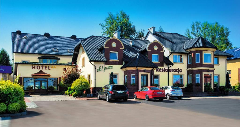 a large house with cars parked in front of it at Hotel Sezam Kraczkowa in Kraczkowa