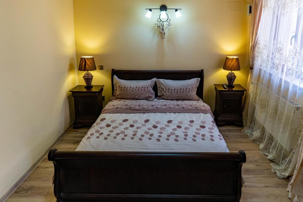 - une chambre avec un lit et 2 lampes sur 2 tables dans l'établissement La Bebe 1 Bed, à Hunedoara