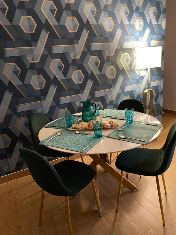 stół z 4 krzesłami i niebieską ścianą w obiekcie B&B Smeralda w mieście Villa San Giovanni