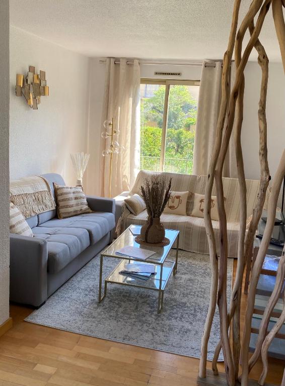 un salon avec un canapé et une table dans l'établissement Saint Tropez Spacieux Appartement La Florida, à Saint-Tropez