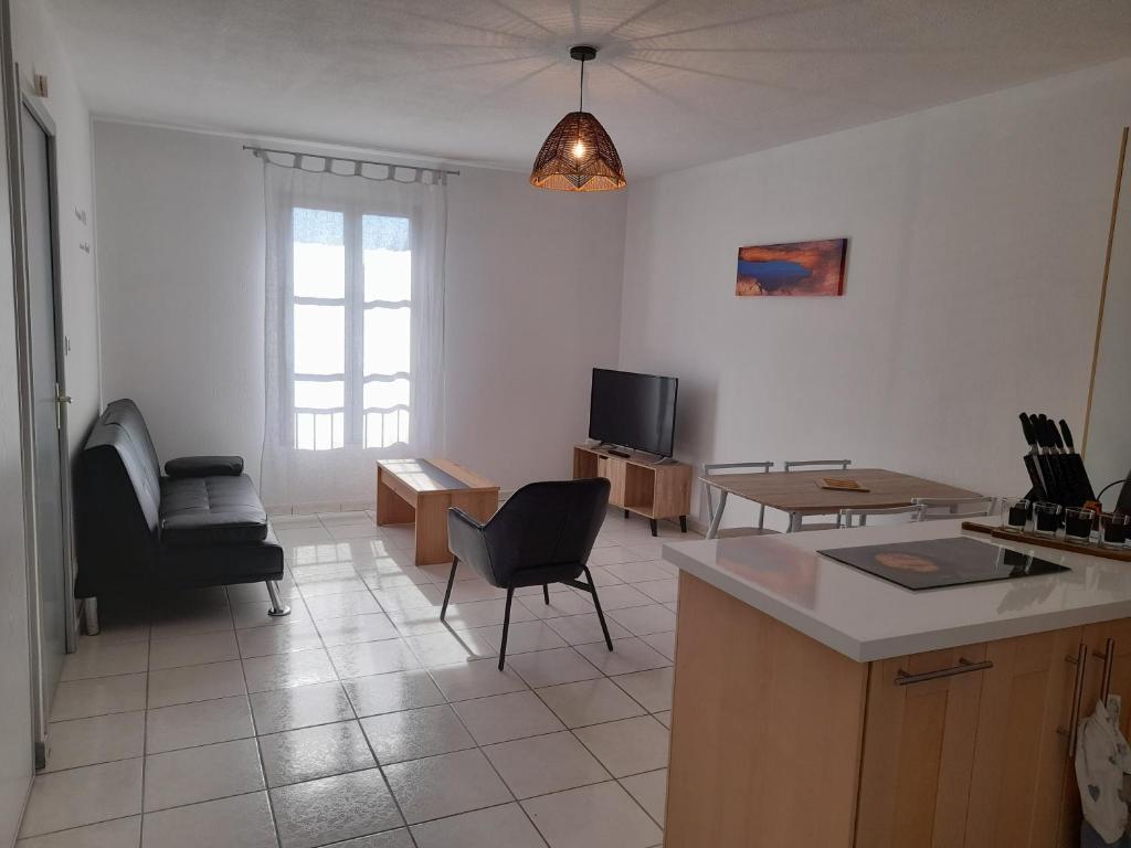cocina y sala de estar con mesa y sillas en le gazounet, en Castelsarrasin