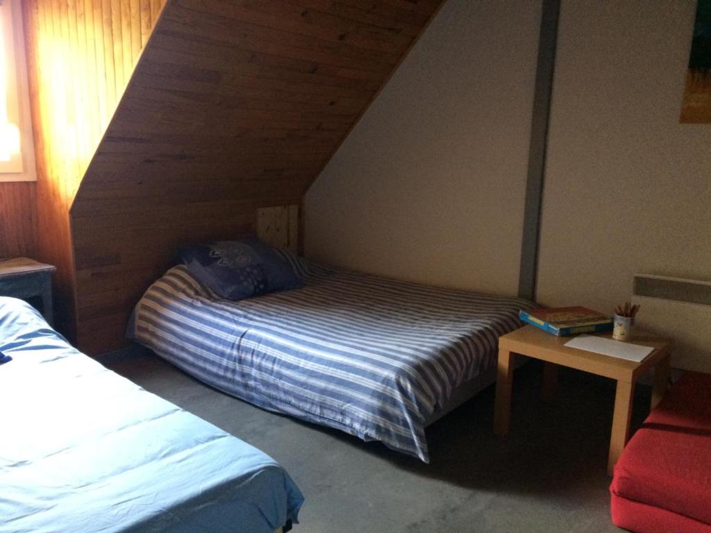 niewielka sypialnia z łóżkiem i stołem w obiekcie Appartement dans grange w mieście Aucun