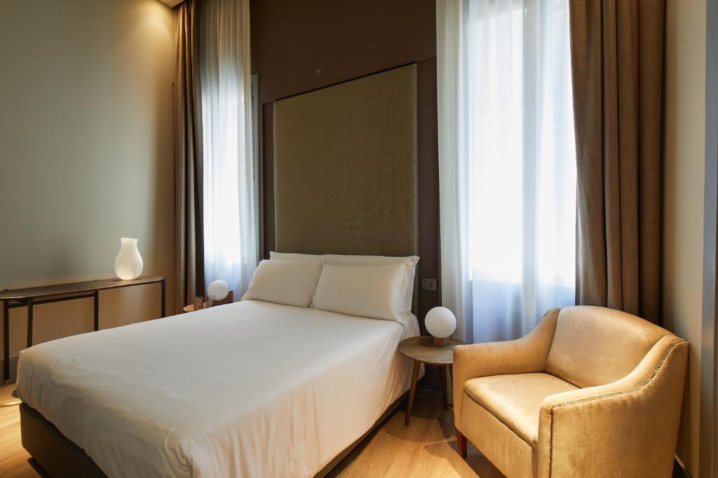 a hotel room with a bed and a chair at Hotel Dei Dragomanni in Venice
