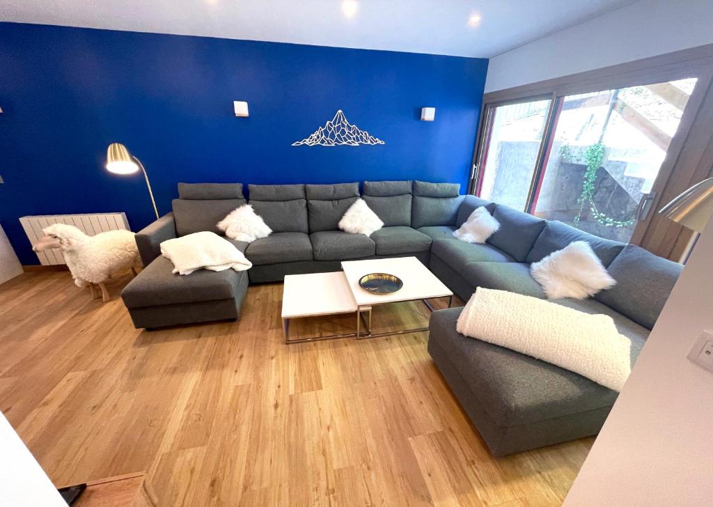 a blue living room with a couch and a table at Les Moutons de Cauterets - garage privé in Cauterets