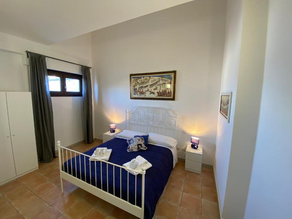 1 dormitorio con 1 cama azul y 2 mesitas de noche en Le casette di Frà al Bondì, en Santa Severa