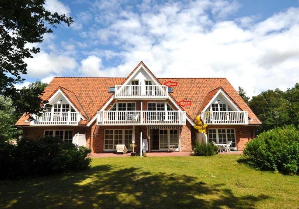 a large brick house with white balconies at Appartementhaus Appartement Strandläufer in Süderhöft