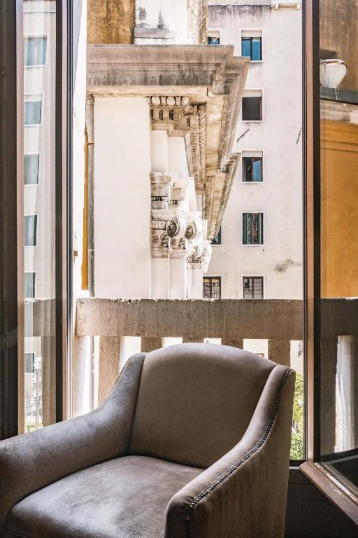 a couch in front of a window with a view of a building at Hotel Dei Dragomanni in Venice