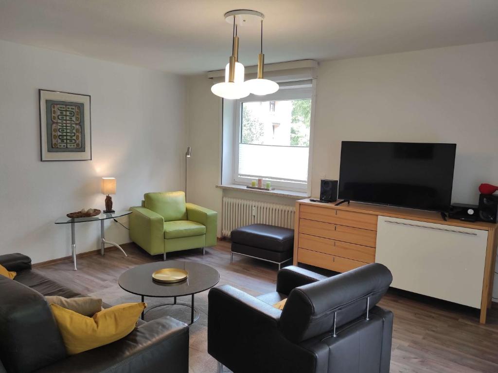 een woonkamer met een bank en een flatscreen-tv bij Ferienwohnung Bergwiese 20 in Bad Harzburg