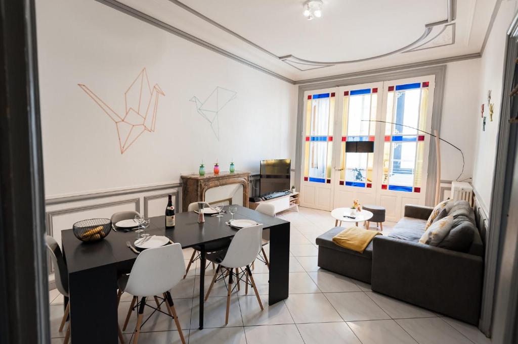 a living room with a table and a couch at L'Atlantide Apt 85m2 3 chambres - Appart Hotel Poitiers in Poitiers
