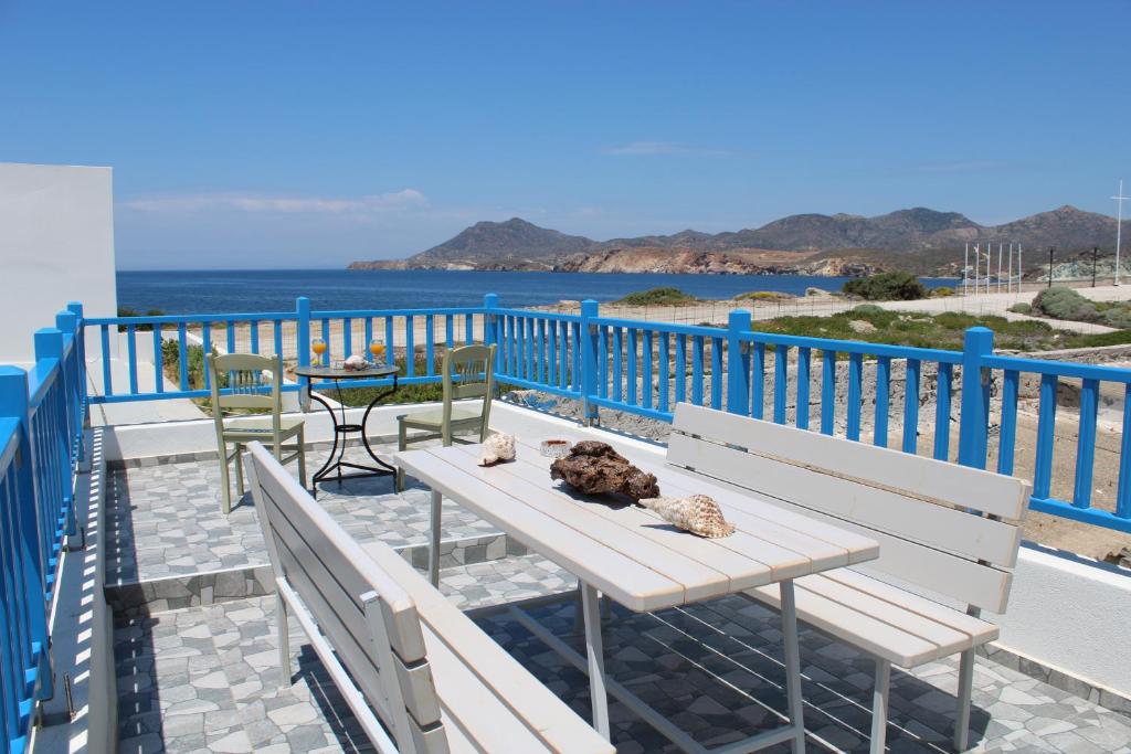 d'une table et de chaises sur un balcon avec vue sur l'océan. dans l'établissement Harmony Villa Milos, à Pollonia