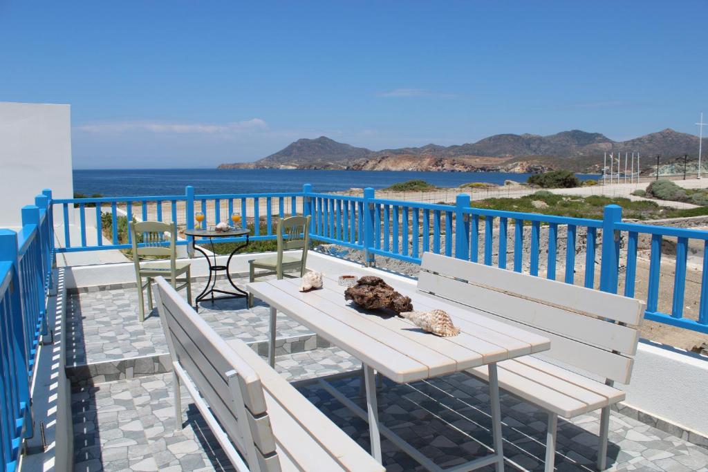 a table and chairs on a balcony with a view of the ocean at Harmony Villa Milos in Pollonia
