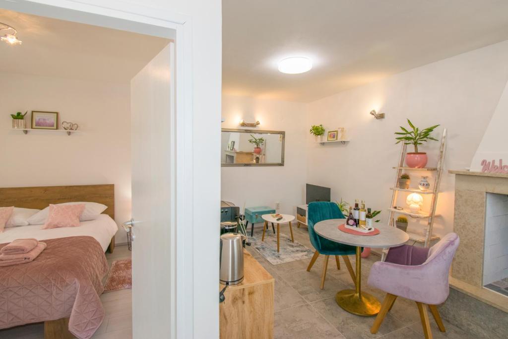 Cet appartement comprend une chambre avec un lit et un salon avec une table. dans l'établissement Apartman Enjoy, à Rovinj