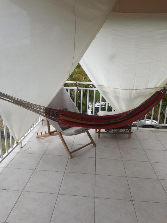 a hammock sitting on a balcony with a balcony at JOYAUX DE TIVOLI VILLA in Fort-de-France