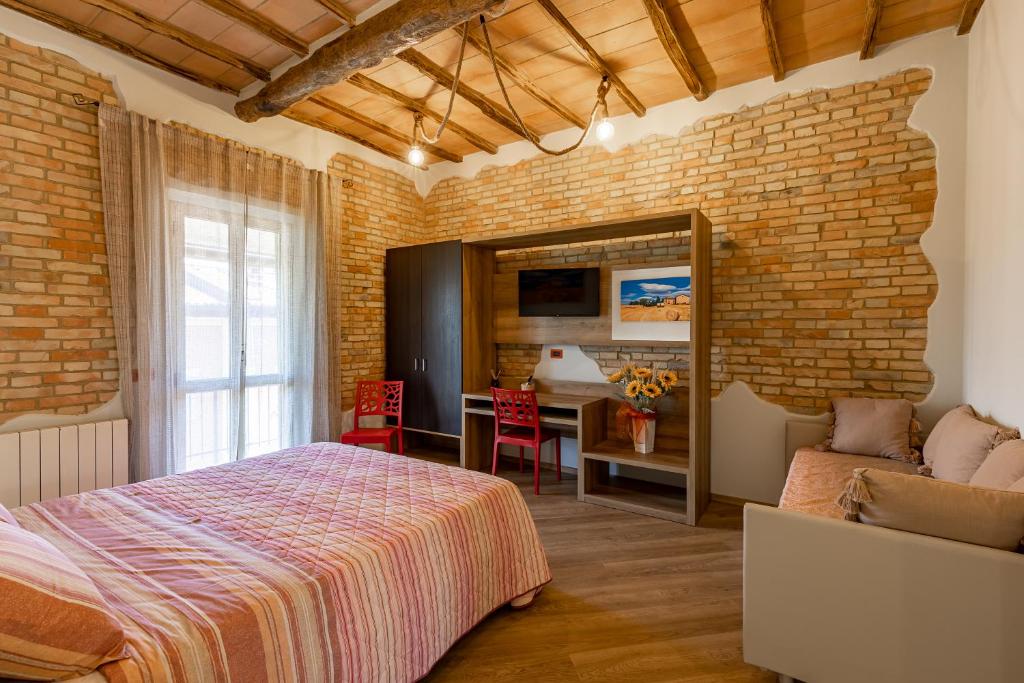 una camera con letto e muro di mattoni di Elegante Casa Mafalda con vista a Montalcino