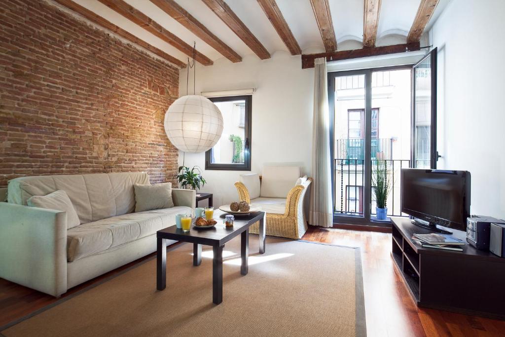 salon z białą kanapą i ceglaną ścianą w obiekcie Inside Barcelona Apartments Esparteria w Barcelonie