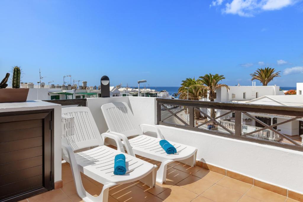 a pair of white chairs sitting on a balcony at Holiday in Lanzarote! in Tías