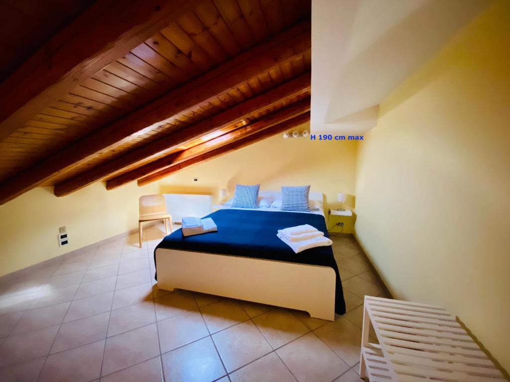 a bedroom with a bed with blue sheets in a room at Torre Archirafi Vacanze in Riposto