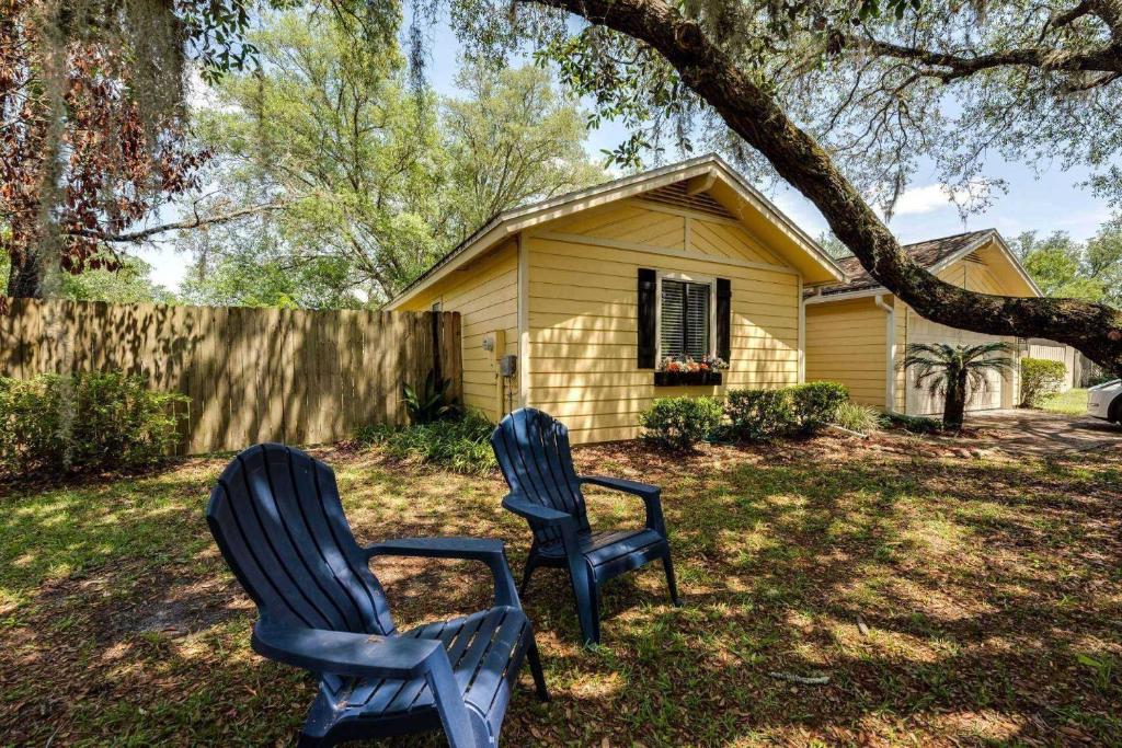 two blue chairs sitting in a yard in front of a house at Sunny Lemon in Middleburg