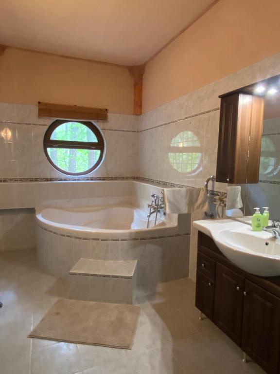 uma casa de banho com uma banheira e um lavatório em Ambiente em Kiskunhalas