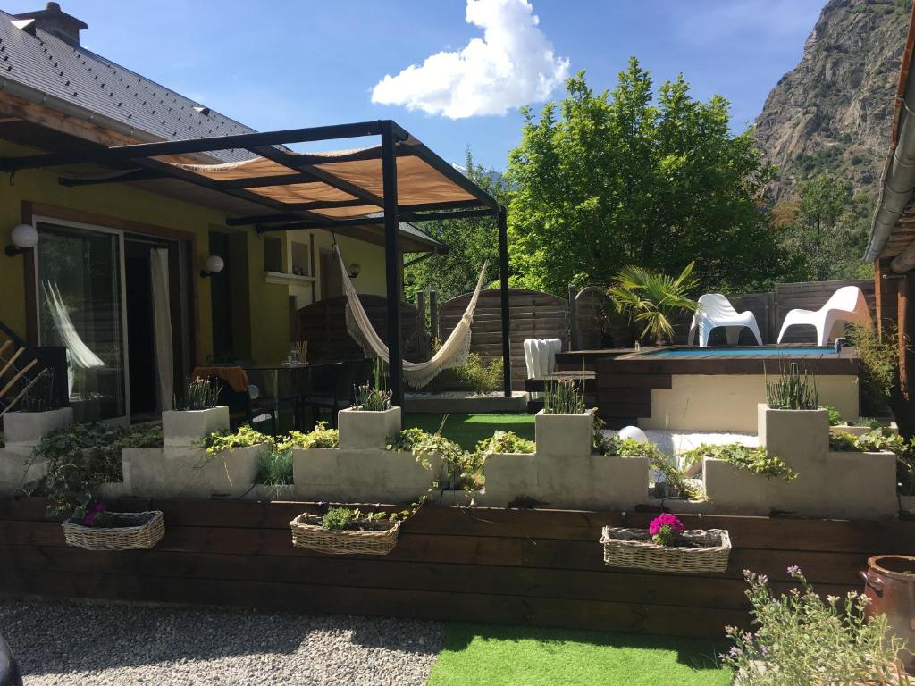 um quintal com um pátio com cadeiras e plantas em Ô Lit' Chi em Hermillon