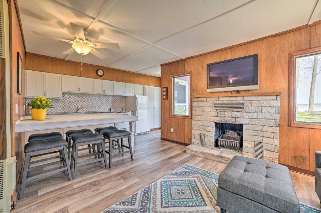 a kitchen with a living room with a fireplace at Cozy Petoskey Area Retreat on Burt Lake Access! 