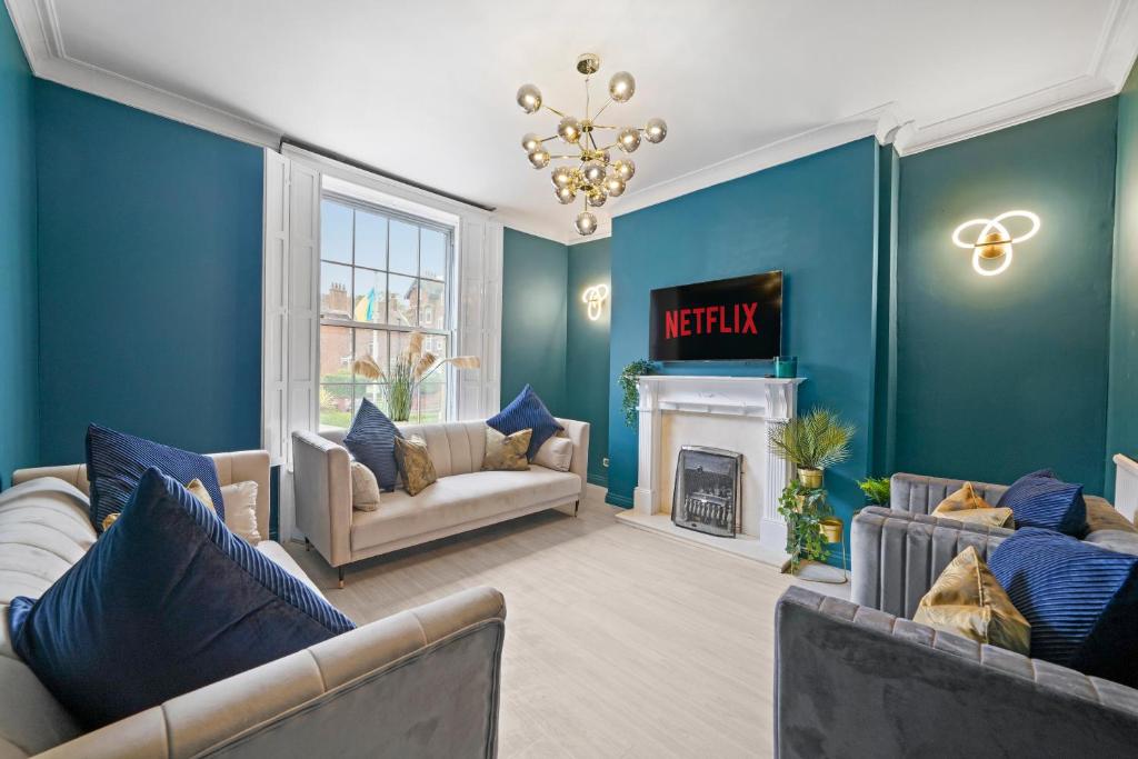 a blue living room with two couches and a fireplace at The Most Central and Lux Whitby House - Hot-Tub in Whitby
