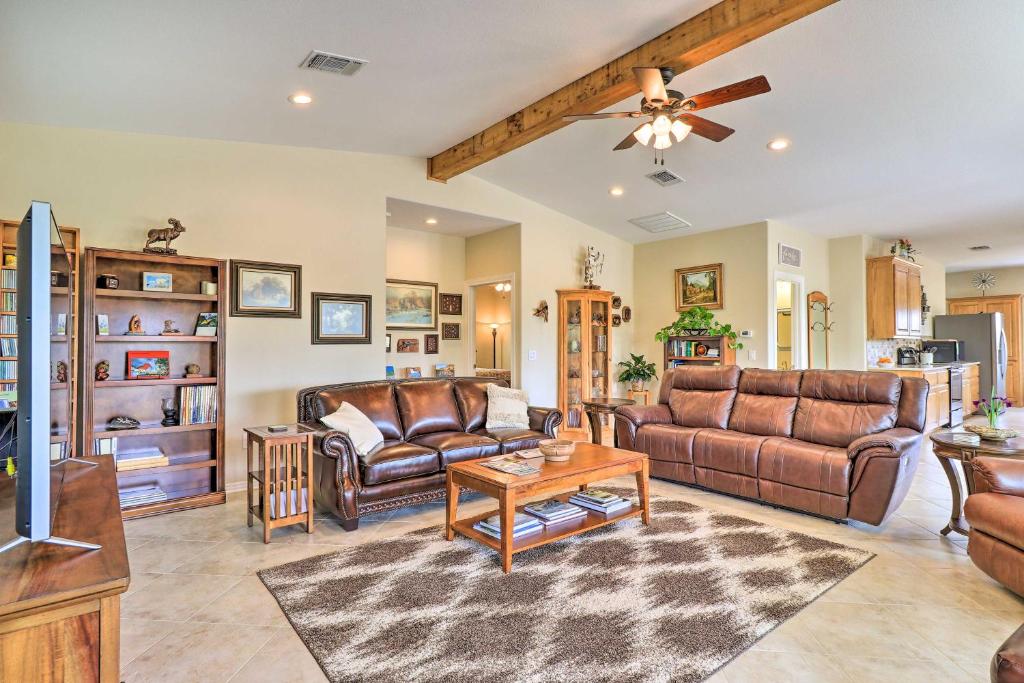 a living room with leather furniture and a ceiling fan at Bertram Ranch Property with Acreage and Trail Access! in Bertram