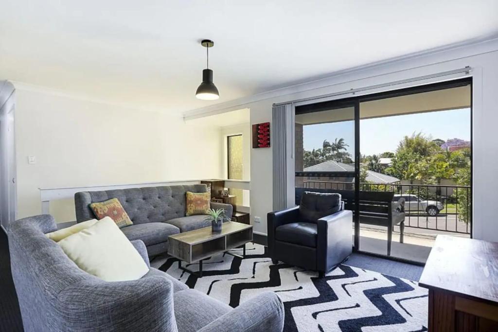 a living room with a couch and a chair at Private Room in Pleasant Ashmore in Gold Coast