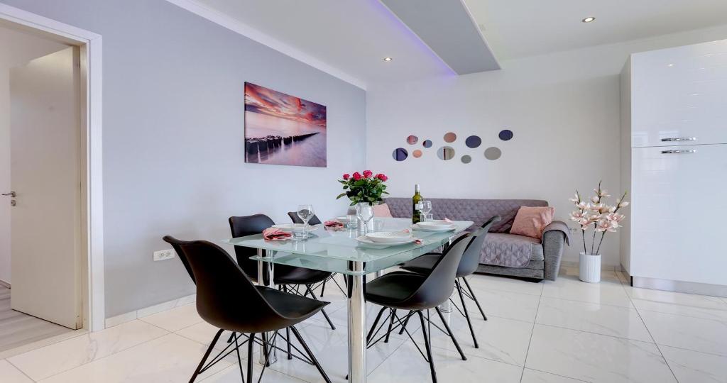 une salle à manger avec une table en verre et des chaises noires dans l'établissement Adorable apartment Ena, à Kaštela