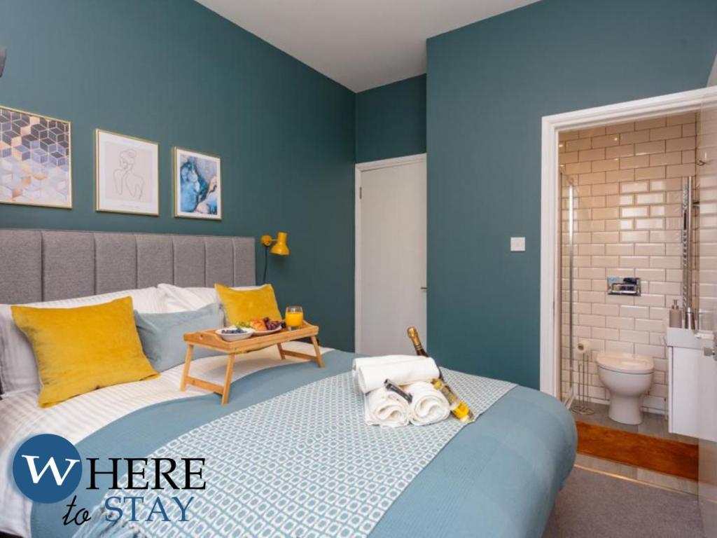 a blue bedroom with a bed and a bathroom at Lovely apartment beneath Edinburgh Castle in Edinburgh