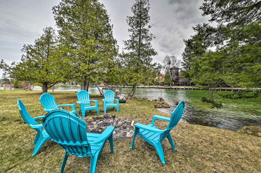 un groupe de chaises bleues assises à côté d'une rivière dans l'établissement Cabin on Inland Waterway River with Boat Dock!, à Cheboygan