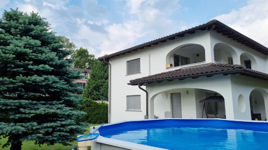 une villa avec une piscine en face d'une maison dans l'établissement Casa MANUELA tra Bellinzona Locarno e Lugano, à Cadenazzo