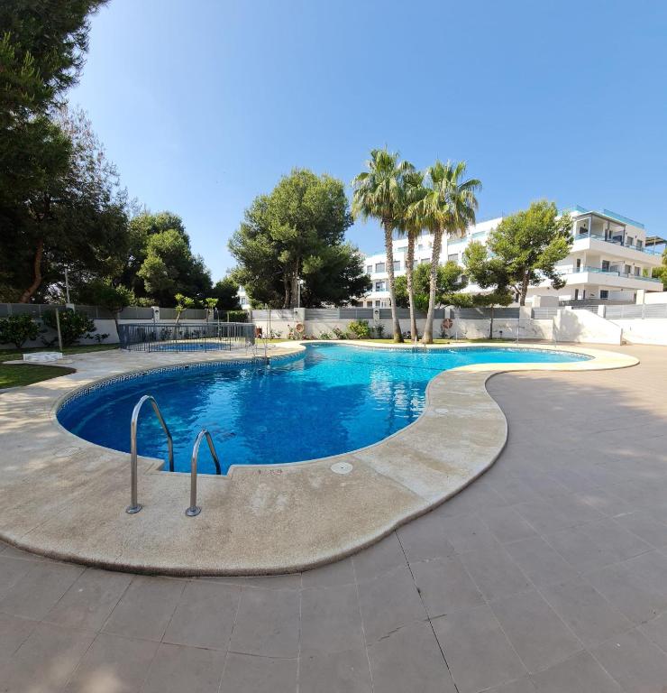 a swimming pool in a resort with trees and a building at Casa Soñada - Dream House in Garrucha