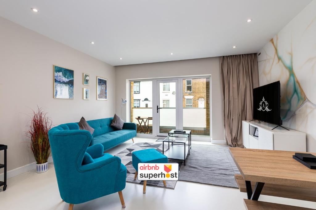 a living room with a blue couch and a tv at Premier Apartments in Gillingham in Gillingham