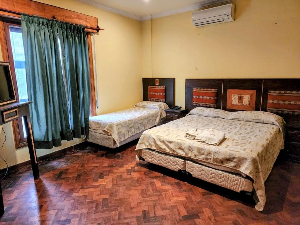 1 dormitorio con 2 camas y TV. en Tradición de Salta en Salta