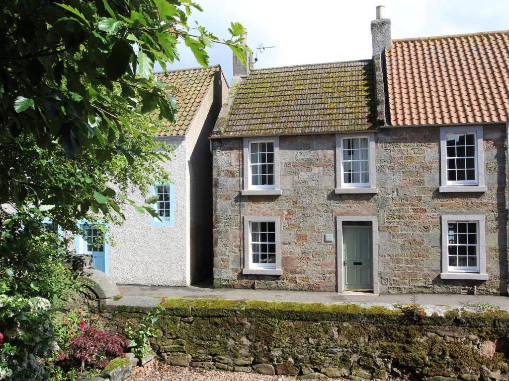 an old stone house with a green door at 16 Westgate South in Anstruther