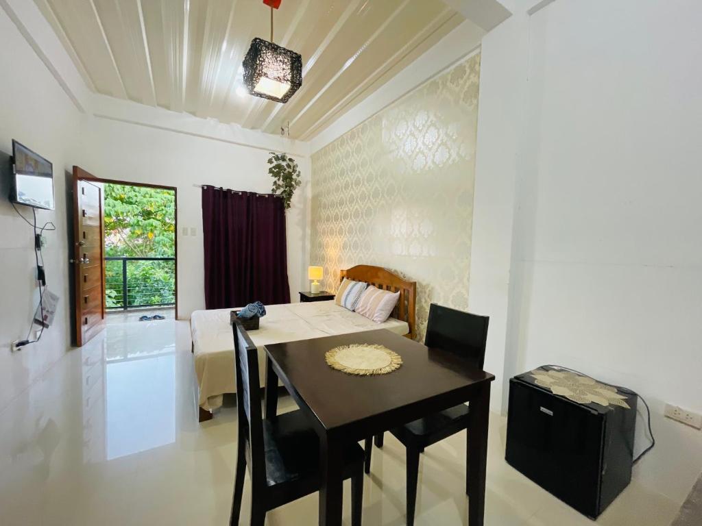 a dining room with a table and a bedroom at Sto Niño Residences Lucena City in Lucena