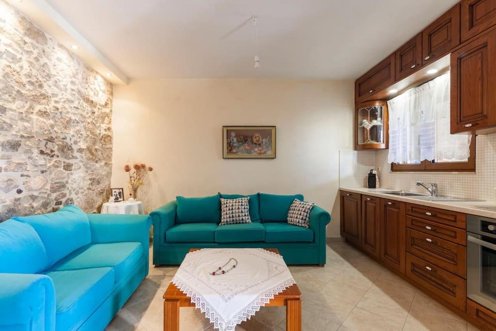 ein Wohnzimmer mit blauen Sofas und eine Küche in der Unterkunft Stella in Panasós