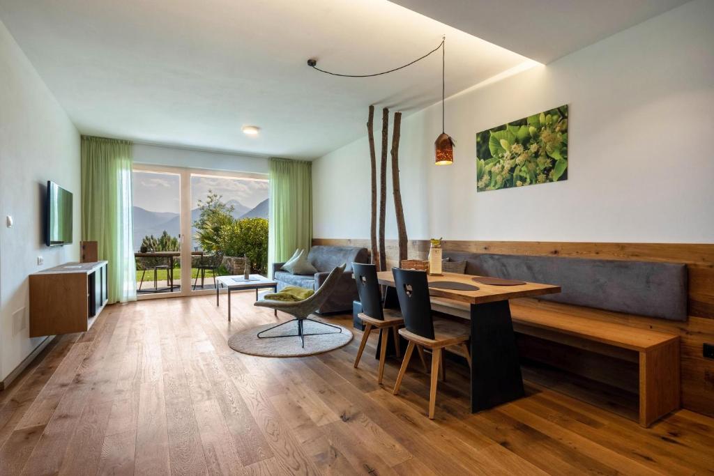 een woonkamer met een tafel en een bank bij Pataunerhof Tilia Lodge in Tirolo