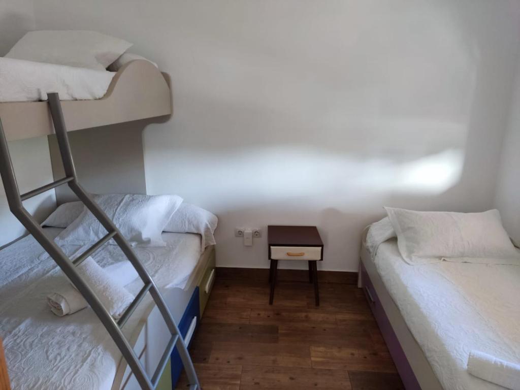 2 Etagenbetten in einem kleinen Zimmer mit einem Tisch in der Unterkunft apartamento el molino con piscina privada in Las Negras