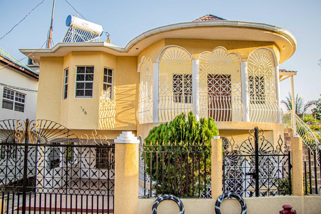 a yellow house with a fence in front of it at CARNATION 156 in Montego Bay