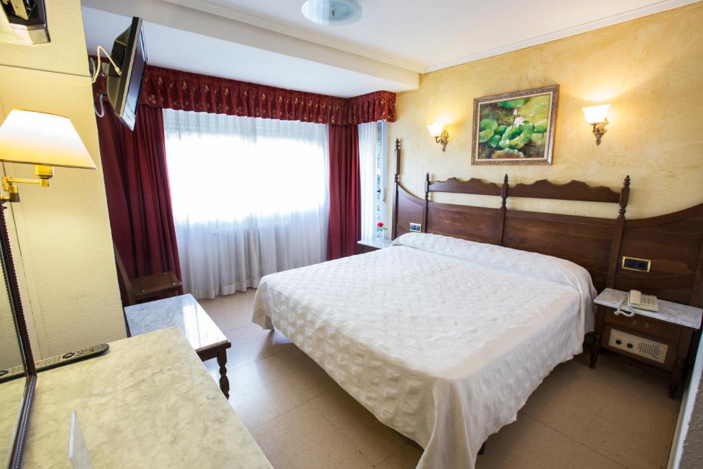 薩拉曼卡的住宿－雷耶斯卡托里克斯酒店，酒店客房设有两张床和窗户。