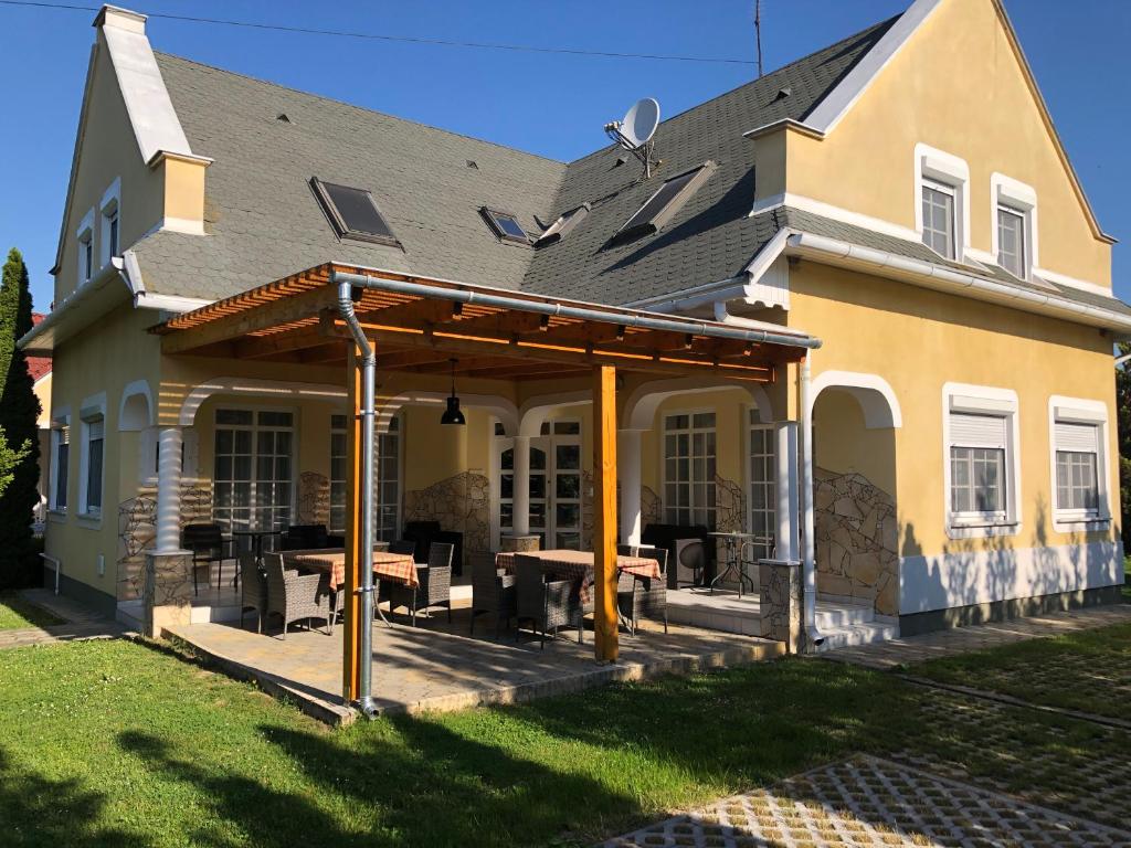 Una casa con un porche con una mesa de picnic. en Pacsirta Apartman, en Lenti