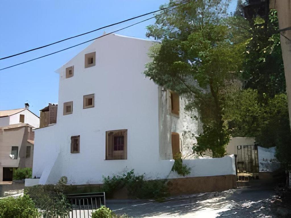 un edificio bianco con un albero di fronte di Casa rural Teresa la Cuca a Jérica